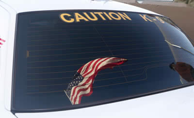Flag in the window of a police car signifying the honorable service of the K9 Teams.